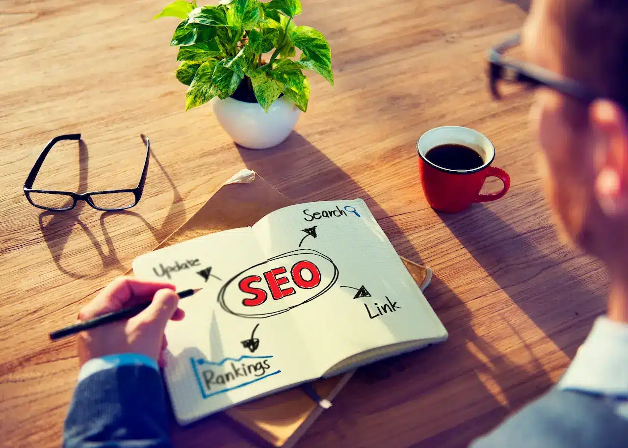 Person Writing SEO Concepts On His Note